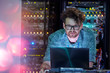 © Agnieszka Olek/Caia Image - Focused male IT technician working at laptop in dark server room