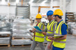 © Sam Edwards/Caia Image - Supervisor and workers walking and talking n warehouse