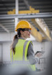 © Martin Barraud/Caia Image - Confident, smiling female worker using digital tablet in factory