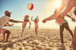 © Trevor Adeline/Caia Image - Playful young friends playing with beach ball on sunny summer beach