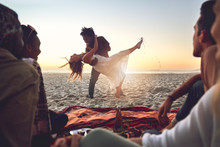 Playful Young Couple Dancing On Sunny Summer Beach