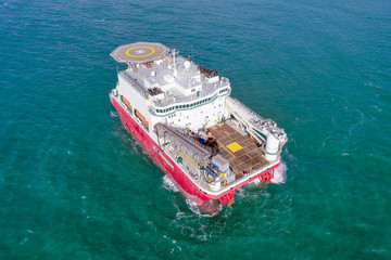 Wall Mural - Large Platform supply ship with Helipad and two large cranes, anchored at Sea, Aerial view.