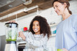 © Sam Edwards/Caia Image - Mother and daughter making healthy green smoothie in blender in kitchen