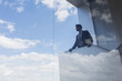 © Caiaimage/Martin Barraud/Caia Image - Businessman on modern balcony looking out window at blue sky clouds