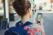 © Caiaimage/Paul Bradbury/Caia Image - Young female tourist backpack using GPS on smart phone on urban street
