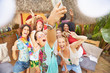 © Trevor Adeline/Caia Image - Enthusiastic young friends taking selfie at sunny summer poolside