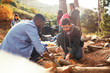 © Trevor Adeline/Caia Image - Young men friends building campfire at campsite