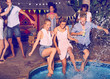 © Trevor Adeline/Caia Image - Playful young friends jumping into swimming pool