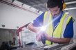 © Martin Barraud/Caia Image - Male engineer with power drill assembling equipment in steel factory
