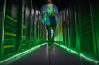 © Rafal Rodzoch/Caia Image - IT technician walking in dark, glowing server room