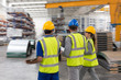 © Sam Edwards/Caia Image - Workers walking and talking in factory