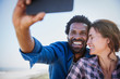 © Sam Edwards/Caia Image - Affectionate, happy multi-ethnic couple taking selfie camera phone