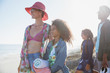 © Sam Edwards/Caia Image - Smiling mother and daughter looking away on sunny summer beach