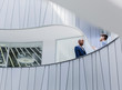 © Caiaimage/Martin Barraud/Caia Image - Businessmen talking on architectural, modern office balcony