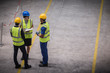© Martin Barraud/Caia Image - Supervisor and workers with clipboard talking in factory