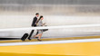 © Caiaimage/Martin Barraud/Caia Image - Businessman and businesswoman with suitcase running up airport ramp