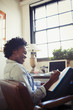 © Caiaimage/Paul Bradbury/Caia Image - Smiling businesswoman reviewing paperwork at desk