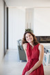 © Sam Edwards/Caia Image - Portrait smiling, confident brunette woman in red dress at home