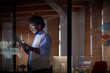 © Caiaimage/Agnieszka Olek/Caia Image - Smiling businesswoman working late, using digital tablet in dark office at night