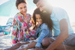 © Sam Edwards/Caia Image - Multi-ethnic family relaxing on sunny summer beach