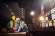 © Caiaimage/Agnieszka Olek/Caia Image - Steelworkers using laptop in steel mill