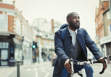 African Businessman Commuting, Riding Bicycle On Urban Street