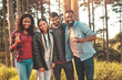 © Trevor Adeline/Caia Image - Portrait confident young friends gesturing peace sign in woods