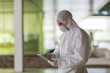 © Caiaimage/Martin Barraud/Caia Image - Scientist in clean suit using digital tablet