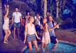 © Trevor Adeline/Caia Image - Young friends dancing and hanging out at summer poolside party at night