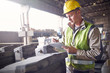 © Caiaimage/Agnieszka Olek/Caia Image - Steelworker writing on clipboard in steel mill