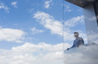 © Caiaimage/Martin Barraud/Caia Image - Pensive businessman standing at modern balcony looking at sunny blue sky clouds