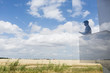 © Caiaimage/Martin Barraud/Caia Image - Silhouette businessman writing on modern balcony overlooking sunny blue sky clouds