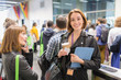 © TomMerton/Caia Image - Portrait smiling businesswoman with coffee at conference
