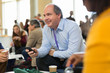 © Martin Barraud/Caia Image - Smiling businessman using smart phone at conference