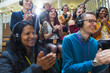 © Sam Edwards/Caia Image - Smiling audience with headphones clapping at conference
