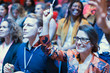© Tom Merton/Caia Image - Smiling woman in conference audience raising hand