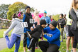 © Sam Edwards/Caia Image - Family runners preparing, stretching at charity run in park