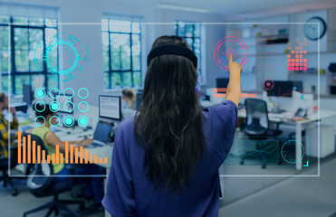 Businesswoman using futuristic hologram computer in office