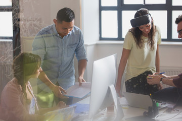 Computer programmers programming virtual reality simulator glasses in office