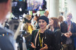© Sam Edwards/Caia Image - Cameraman filming businesswoman talking at conference