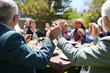 © Trevor Adeline/Caia Image - Active senior friends holding hands, praying at sunny garden party table