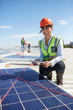 © Trevor Adeline/Caia Image - Portrait confident, smiling female engineer digital tablet examining solar panels at power plant