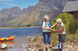 © Trevor Adeline/Caia Image - Active senior couple putting on life jackets, preparing for kayaking at sunny summer lakeside