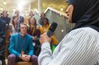 © Sam Edwards/Caia Image - Smiling businesswoman in hijab speaking to audience with microphone