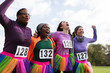 © Sam Edwards/Caia Image - Enthusiastic female runner friends in tutus cheering at charity run