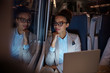 © Agnieszka Olek/Caia Image - Confident, thoughtful businesswoman looking out window on passenger train at night, working at laptop