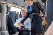 © Agnieszka Olek/Caia Image - Female attendant serving coffee to businessman on passenger train