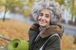 © Tom Merton/Caia Image - Portrait smiling, confident active senior woman with yoga mat