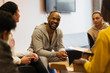 © Sam Edwards/Caia Image - Smiling male mentor talking to teenagers in youth organization