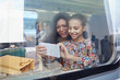 © Agnieszka Olek/Caia Image - Mother and daughter using camera phone at window of passenger train